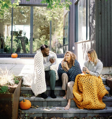 Young adults on porch drinking coffee with blankets #Color_Marigold